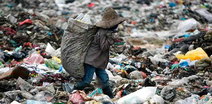 Un hombre busca plástico para reciclar en un sitio de basura en Malasia. FOTOGRAFÍA DE MOHD SAMSUL MOHD SAID, GETTY