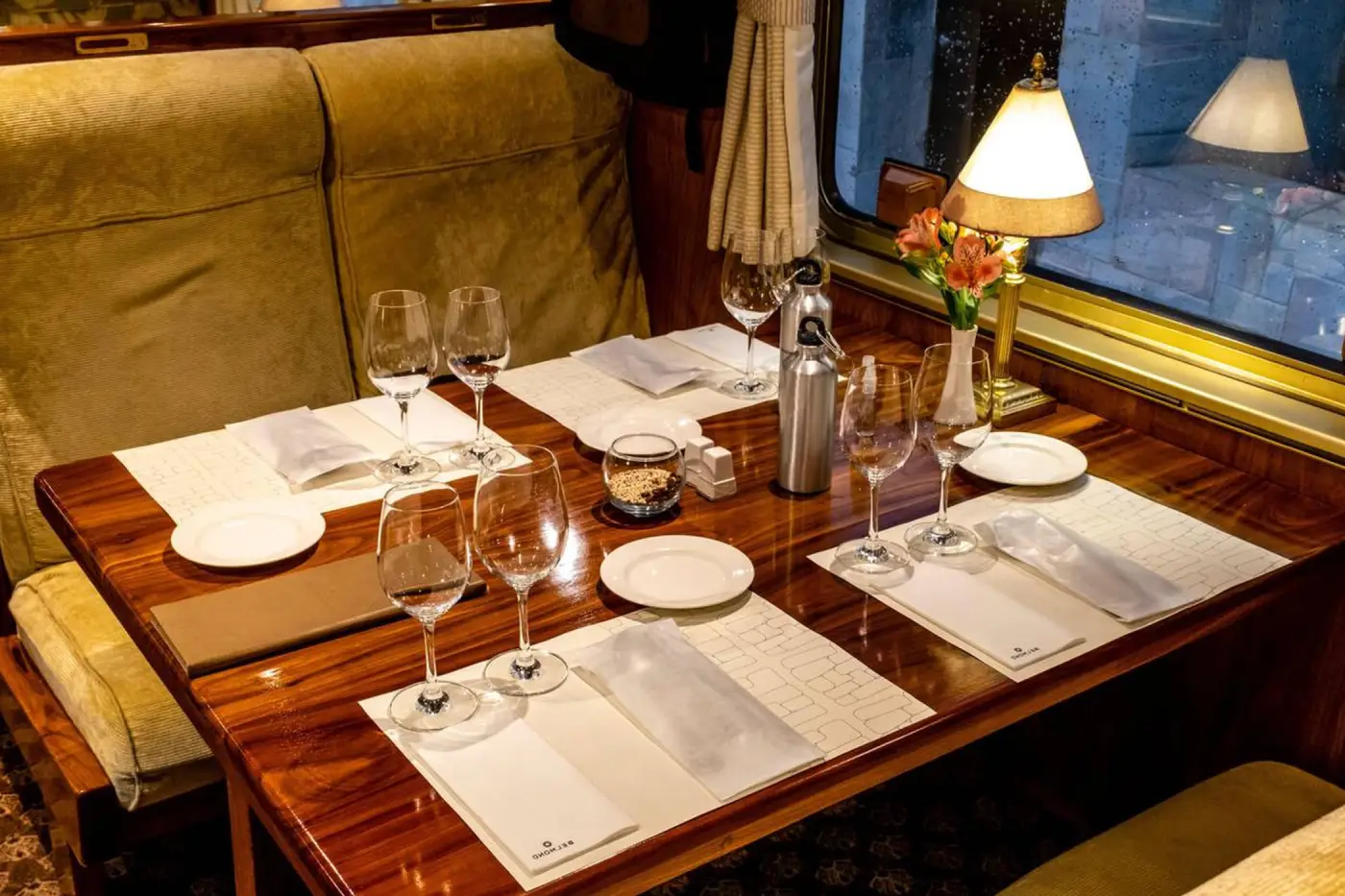 Dining table setup inside the Hiram Bingham train with fine tableware, wine glasses and luxury service on the journey to Machu Picchu.
