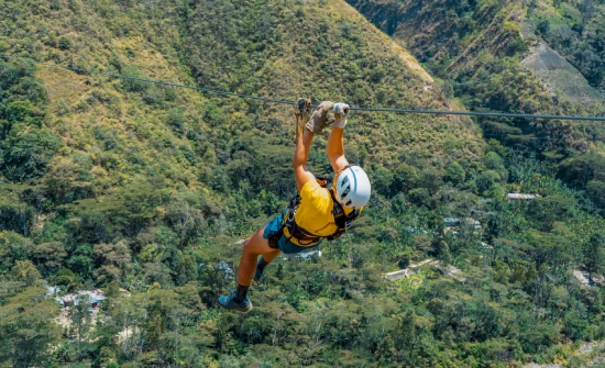 Traveler zip-lining above a green valley during the Inca Jungle Trek to Machu Picchu