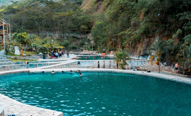 Outdoor hot springs pool with turquoise water, rocks, and jungle greenery near Santa Teresa, Cusco, close to Aguas Calientes and Machu Picchu.