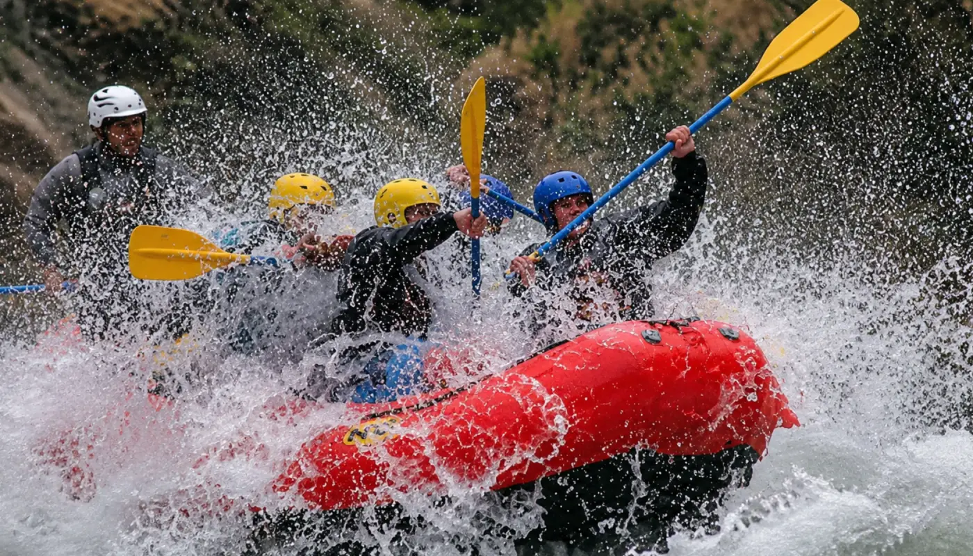 Travelers rafting during the Inca Jungle Trek near Santa Maria, paddling through rapids with helmets and life jackets.