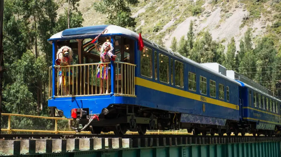 Tourist train to Machu Picchu with Andean dancers on a panoramic carriage in the Sacred Valley.