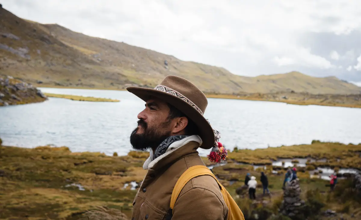 7 lagunas de Ausangate. Un hombre mirando el sendero mientras reposa frente a la laguna de Ausangate