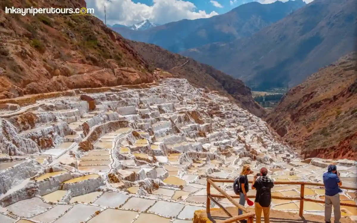 Salineras de Maras en el Valle Sagrado, Cusco, Perú, con pozas blancas de sal en terrazas y montañas al fondo.