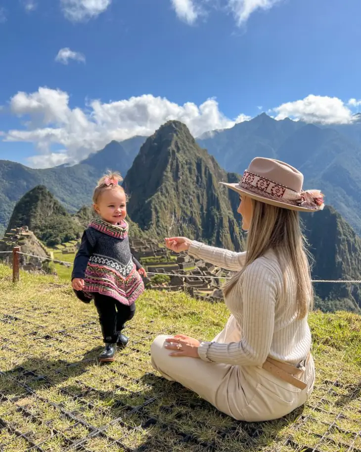 Mother and daughter posing together at Machu Picchu with mountain views