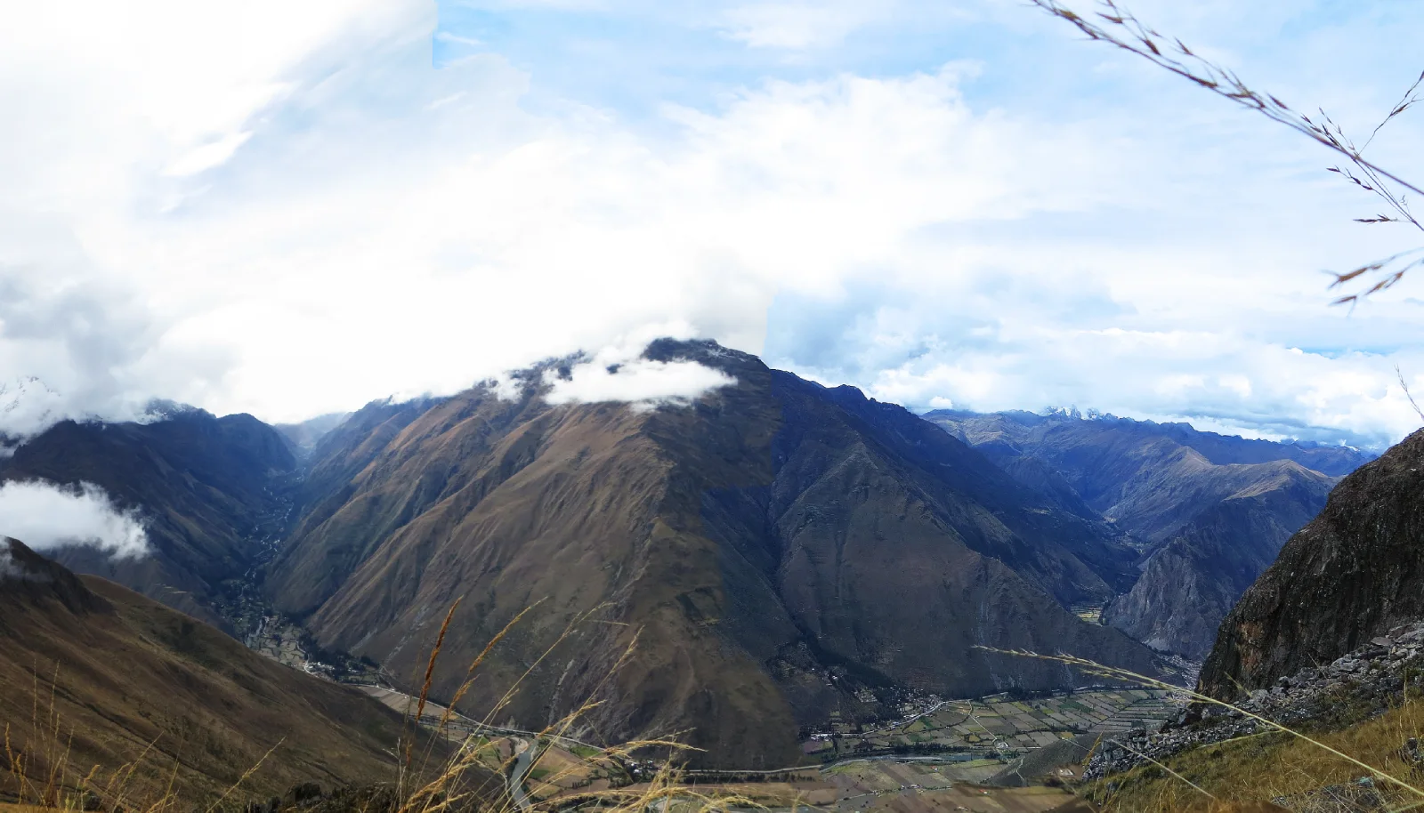 Panoramic view of the Sacred Valley from the Cachicata Inca Quarry Trail near Intipunku, featuring Andean mountains, agricultural terraces and the Urubamba Valley near Ollantaytambo.
