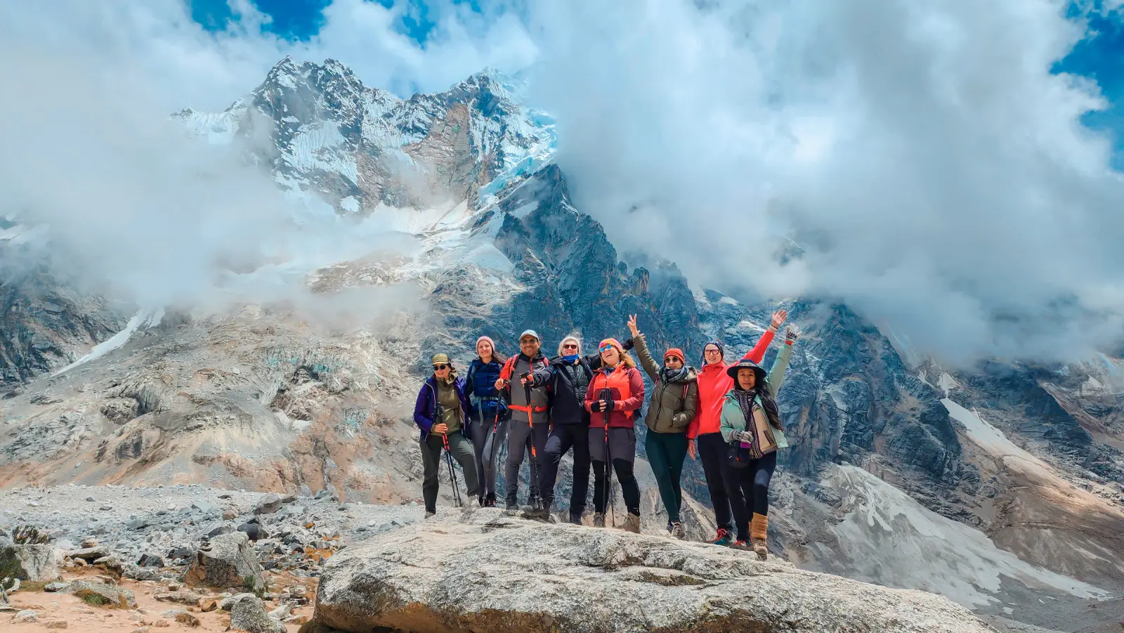 Hikers posing below glacier-covered peaks during the high mountain section of the Salkantay Trek.