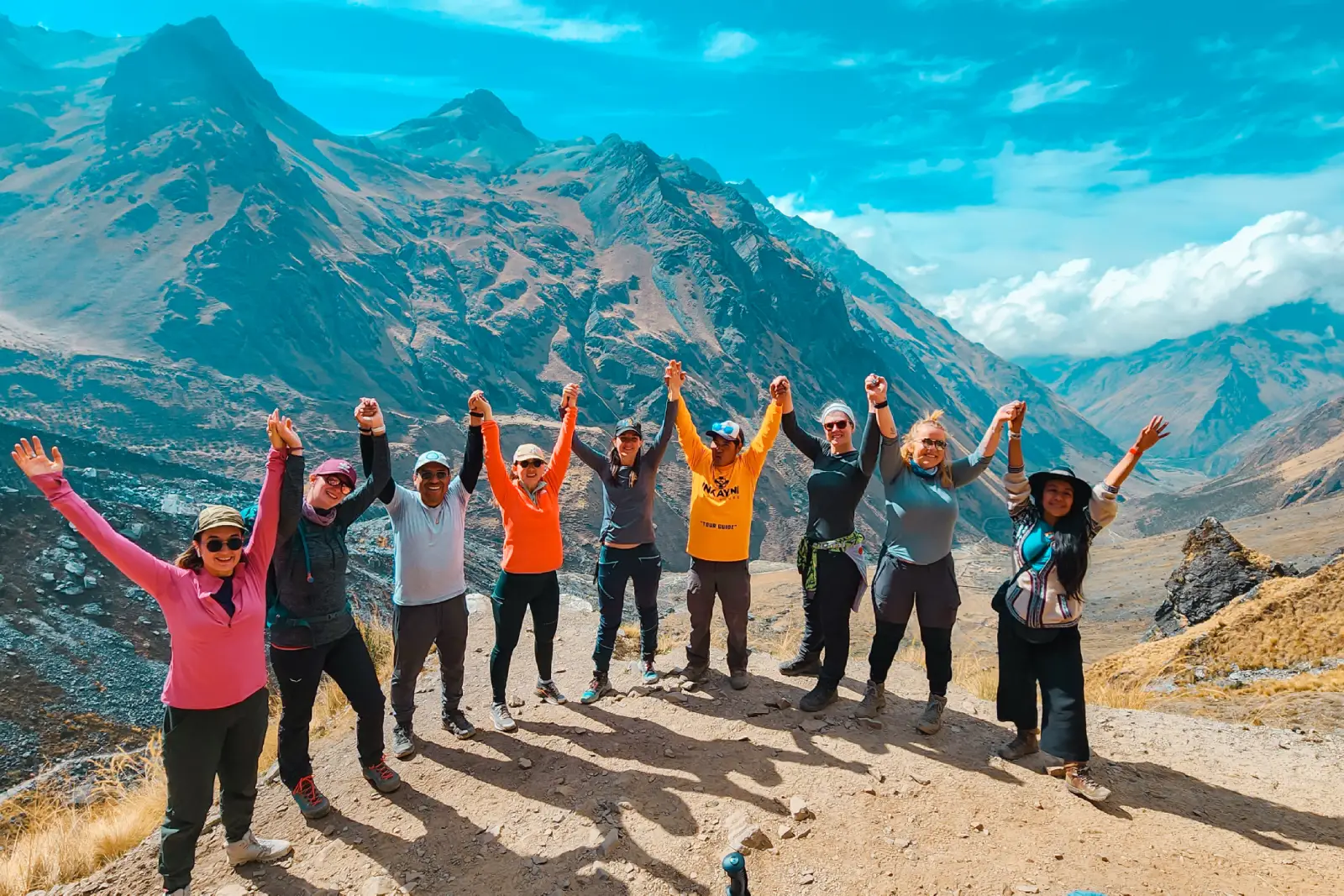 Hikers celebrating at a high-altitude viewpoint before reaching Salkantay Pass on the Salkantay Trek.