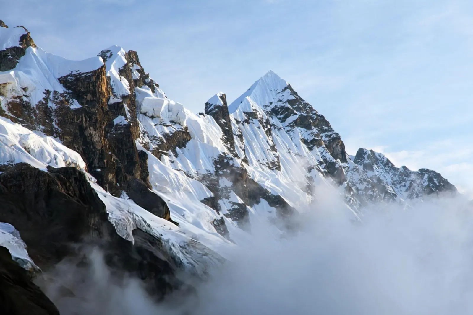Jagged snow and ice ridges on Salkantay Mountain above drifting high-Andean clouds.