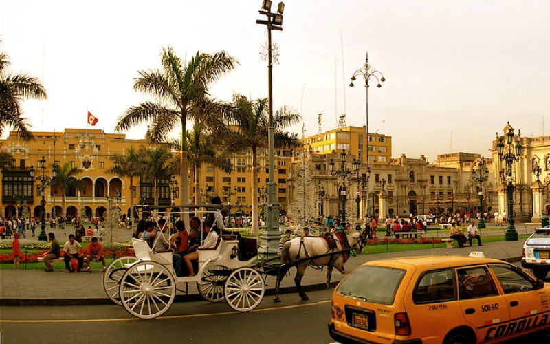 Plazas de Lima. Plaza principal de Lima por la tarde, coches circulando, carruaje en movimiento