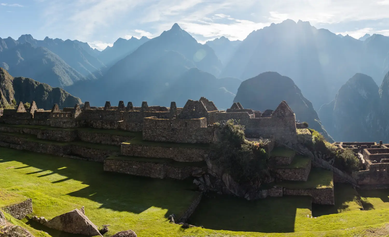 Morning sunlight illuminating Machu Picchu terraces and stone buildings