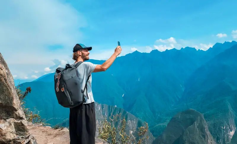 Traveler photographing Andean scenery during the route to Machu Picchu