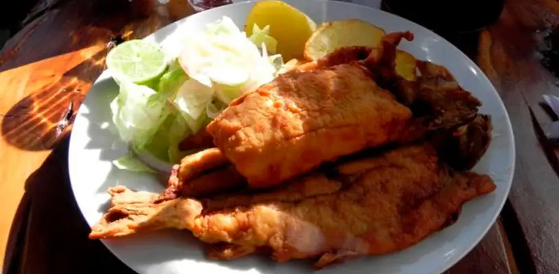 Trucha con papas fritas, acompañado con arroz blanco y ensalada (las papas usualmente se cambia por chuño).