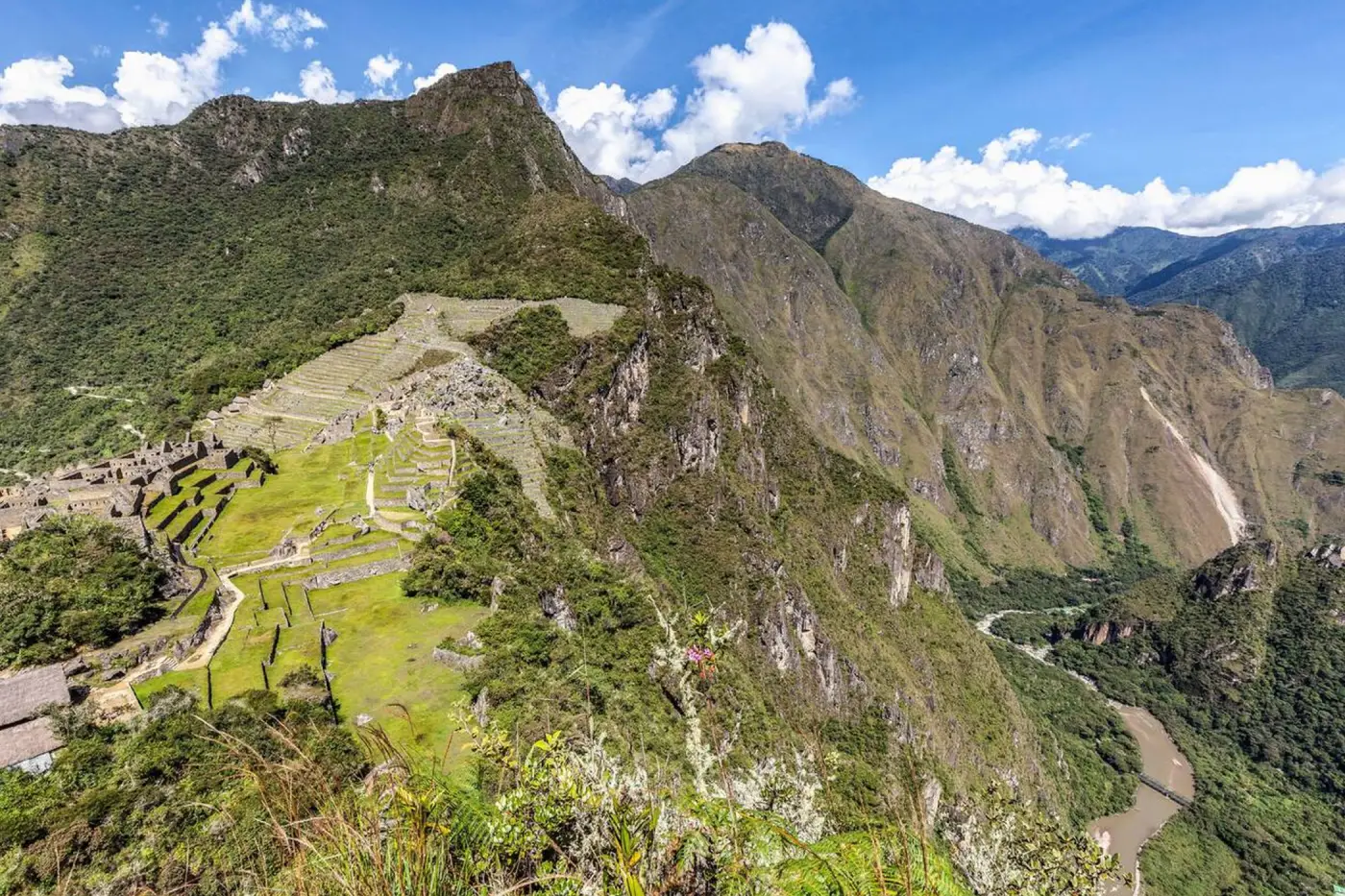 Vista panorámica de Machu Picchu desde la cima del Huchuy Picchu, mostrando las terrazas agrícolas, sectores urbanos y el valle del río Urubamba