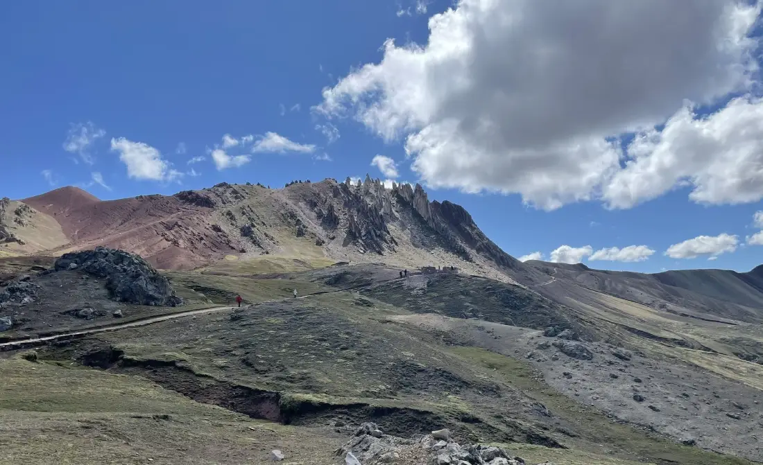 Vista de la montaña de Palccoyo con gente caminando hacia el bosque de piedra