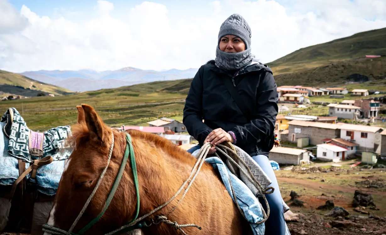 Mujer abrigada y montando a caballo en la Caminata Ausangate