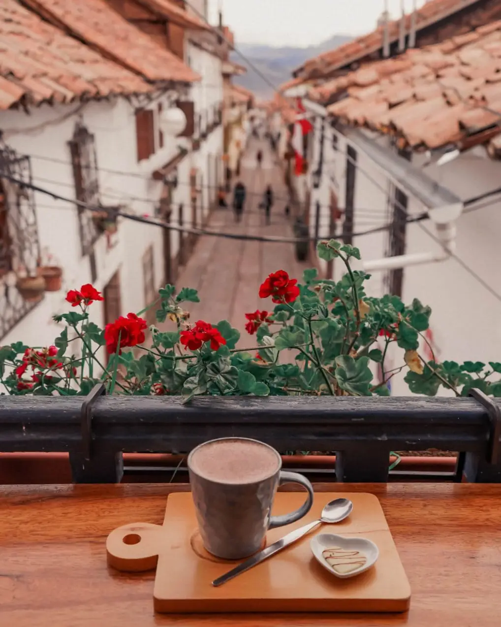 Cusco por la noche cafetería flores taza casas blancas tejas peru
