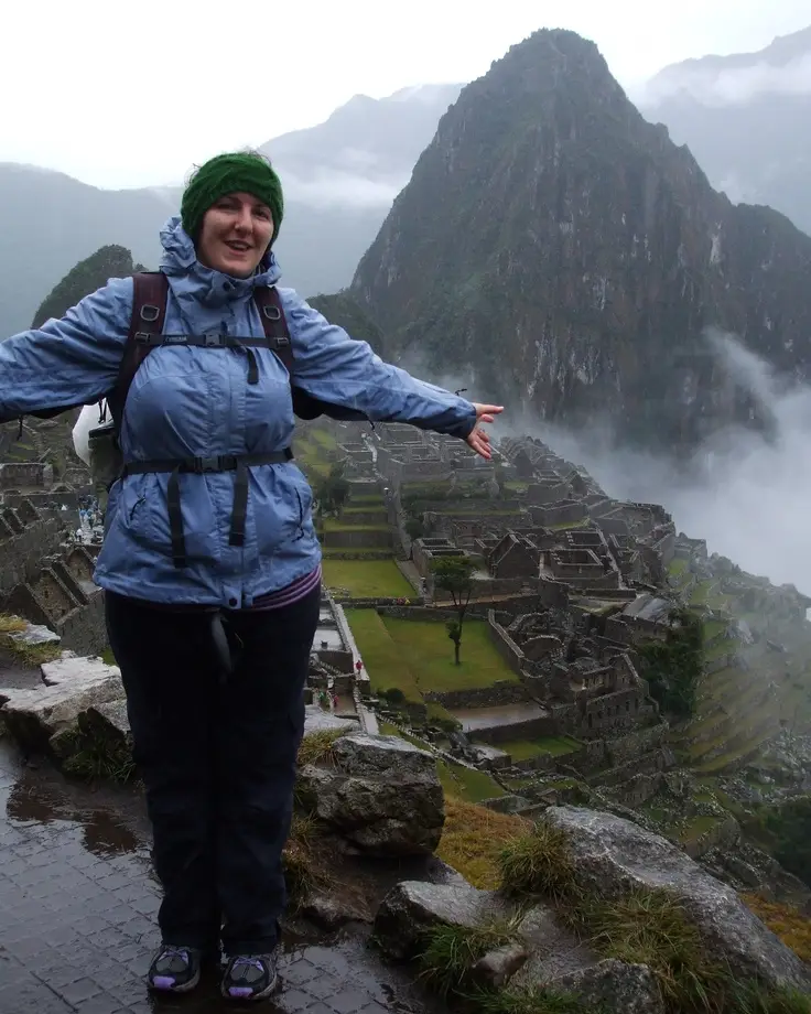 Traveler wearing a raincoat at Machu Picchu during rainy weather