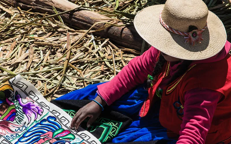 Mujer tejedora con ropa tradicional de Puno, Perú