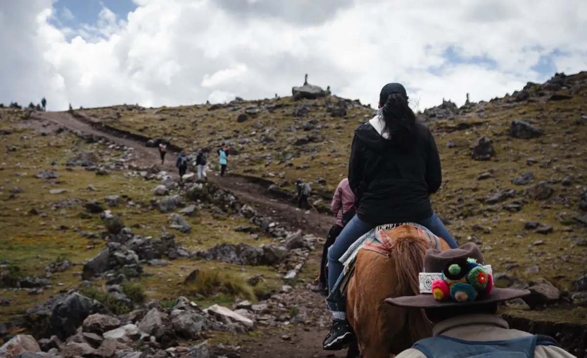 Mujer montando caballo en la ruta de la montaña de Ausangate.