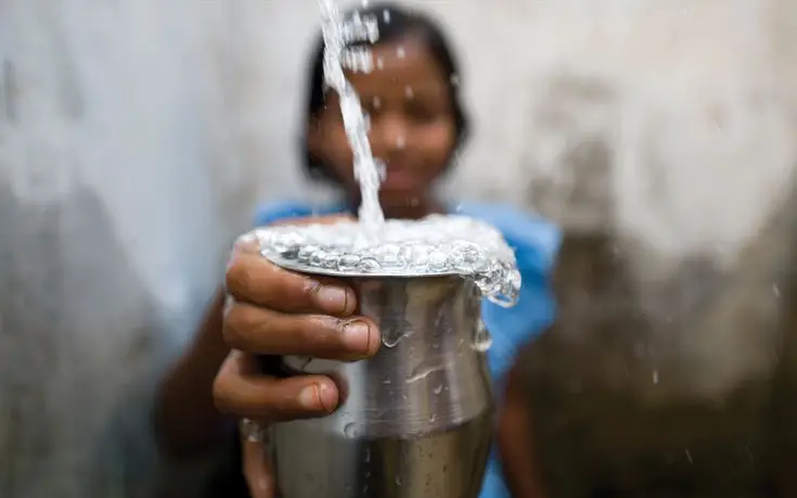 agua en perú vaso rebalsar agua mano niña infancia