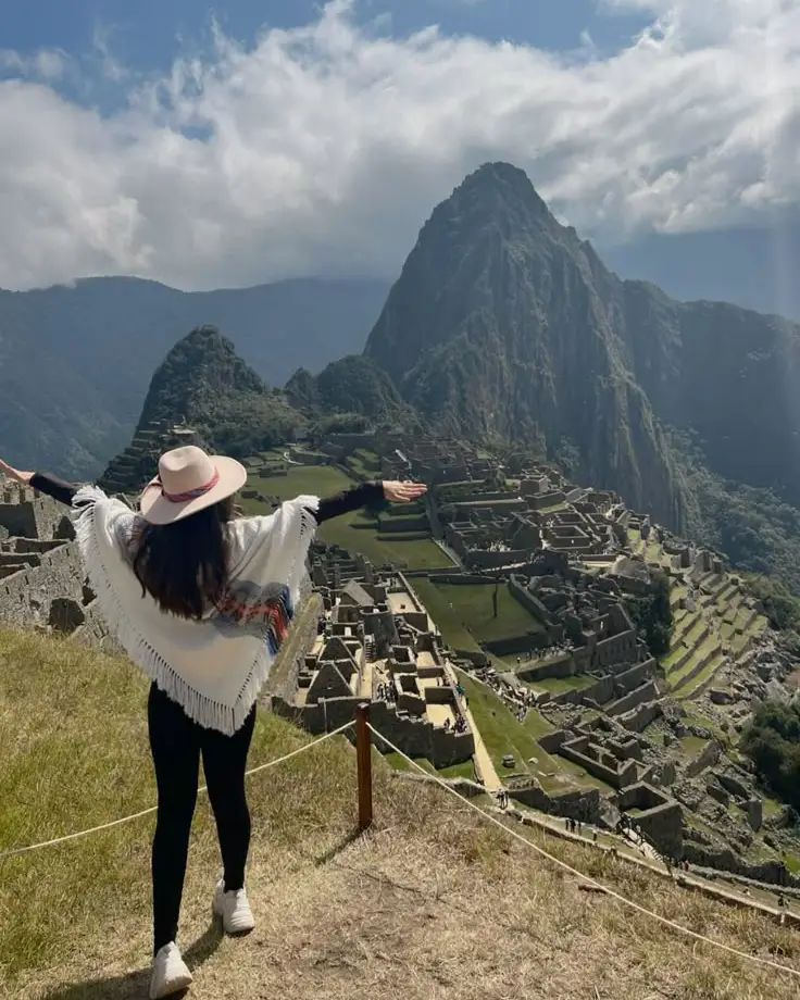 machu picchu desde ee.uu joven viajera turista extranjera aombro ciudadela montañas valle sombrero cusco