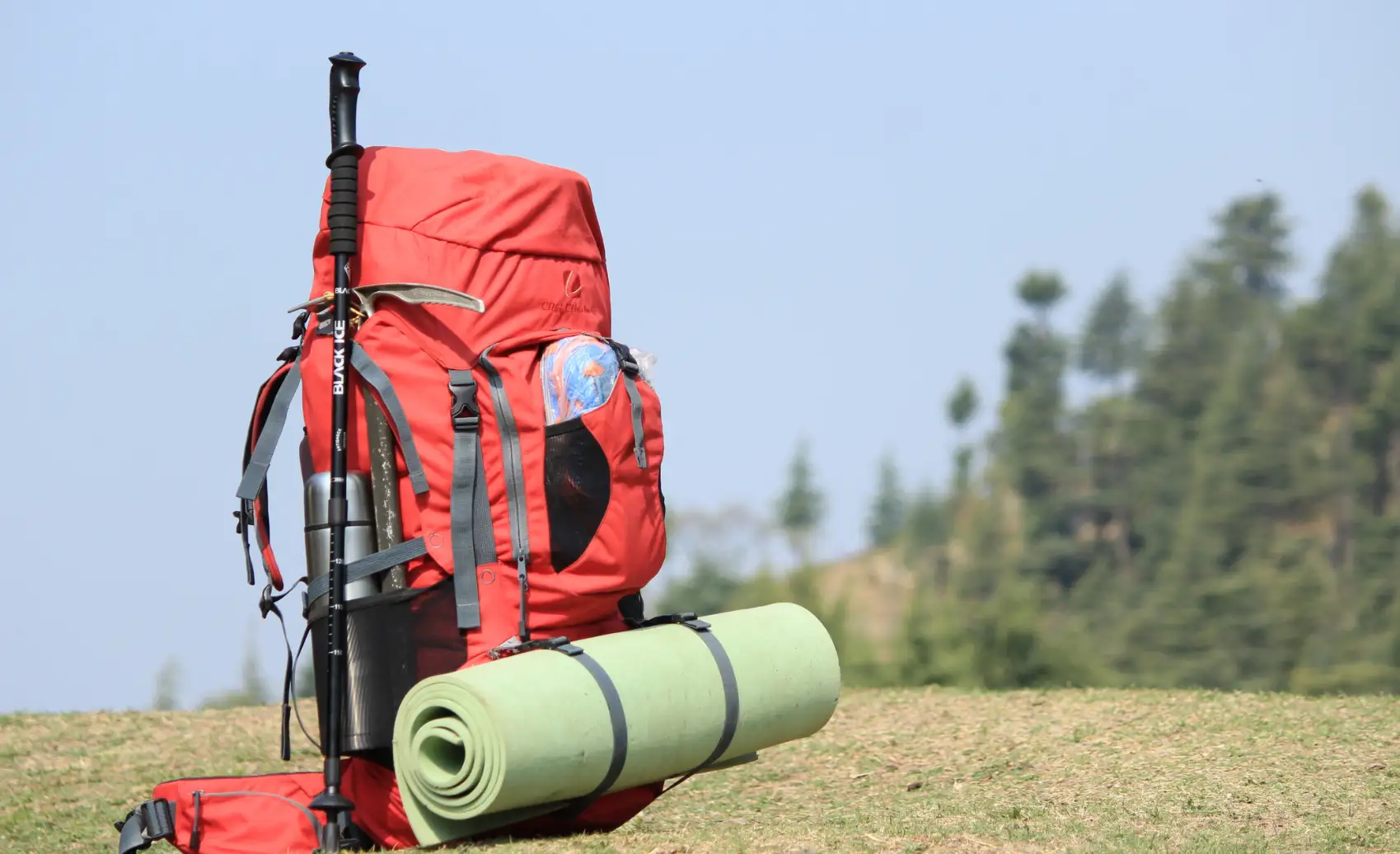 Red multi day trekking backpack standing on trail with trekking poles near Choquequirao Trek in Cusco Peru, ideal for independent hikers.