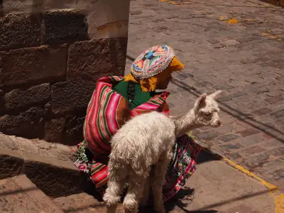 Llama and woman in traditional dress in Cusco, Peru