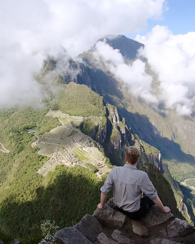 Traveler visiting Machu Picchu from the USA with mountains and cloud forest scenery