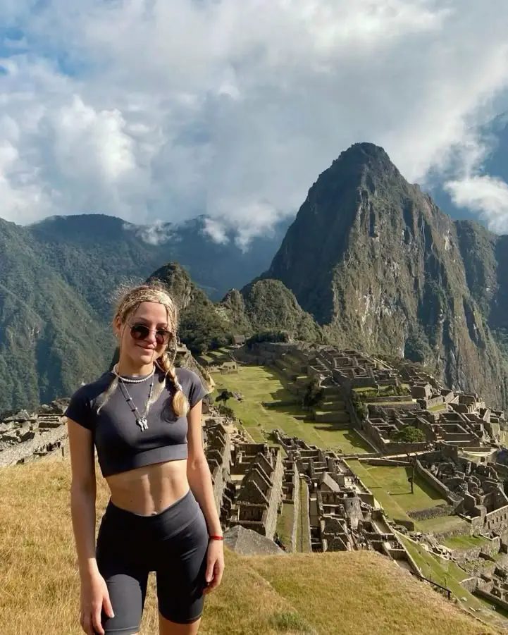 Traveler overlooking Machu Picchu citadel and sacred mountains in Cusco Peru
