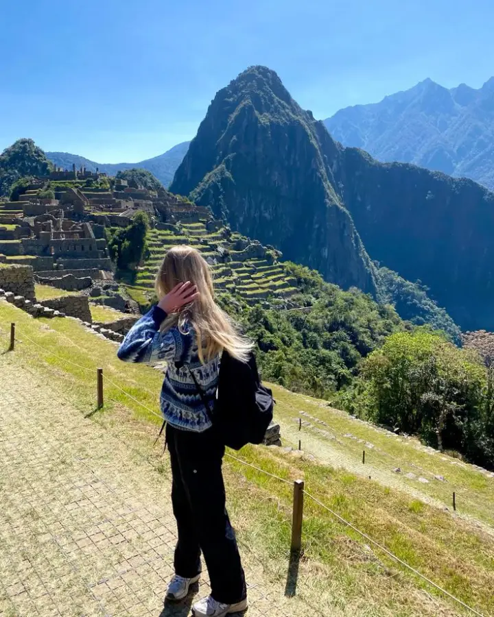 Female traveler at Machu Picchu after traveling from the USA to Peru