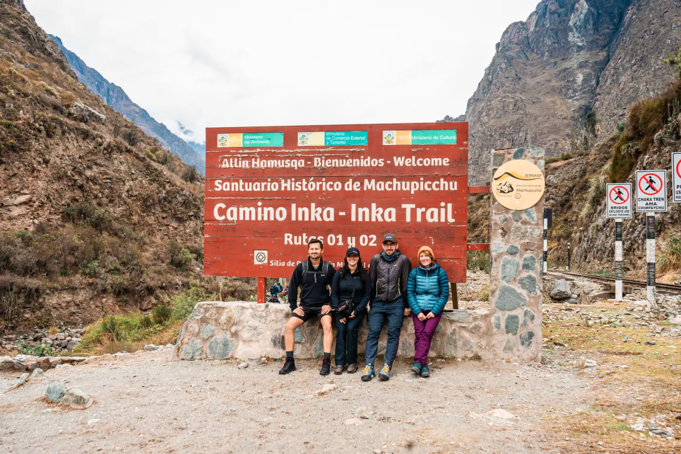 Travelers pose at Km 82 in Piscacucho, the traditional start of the Classic Inca Trail.