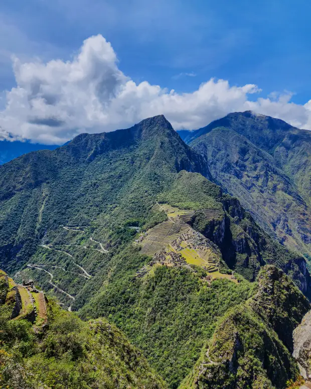 Sendero de la Montaña Machu Picchu con vegetación, nubes y paisaje andino circundante