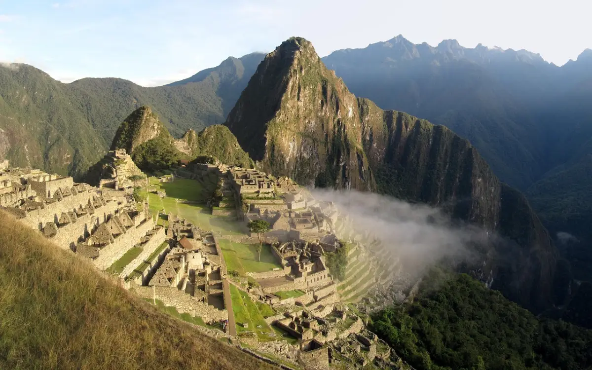 Vista panorámica de las terrazas de Machu Picchu, edificios de piedra y paisaje de montaña circundante