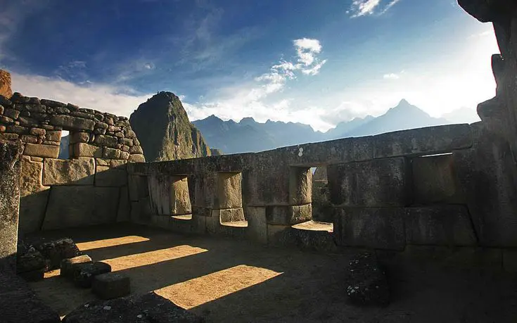 Templo de las Tres Ventanas en Machu Picchu con aberturas trapezoidales y montañas al fondo