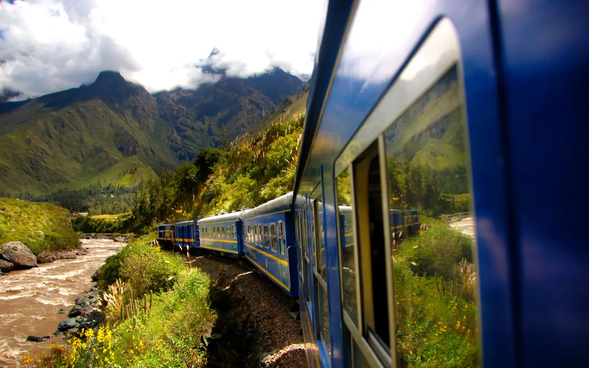 Ruta de tren a Machu Picchu siguiendo el río entre vegetación y paisaje de montaña