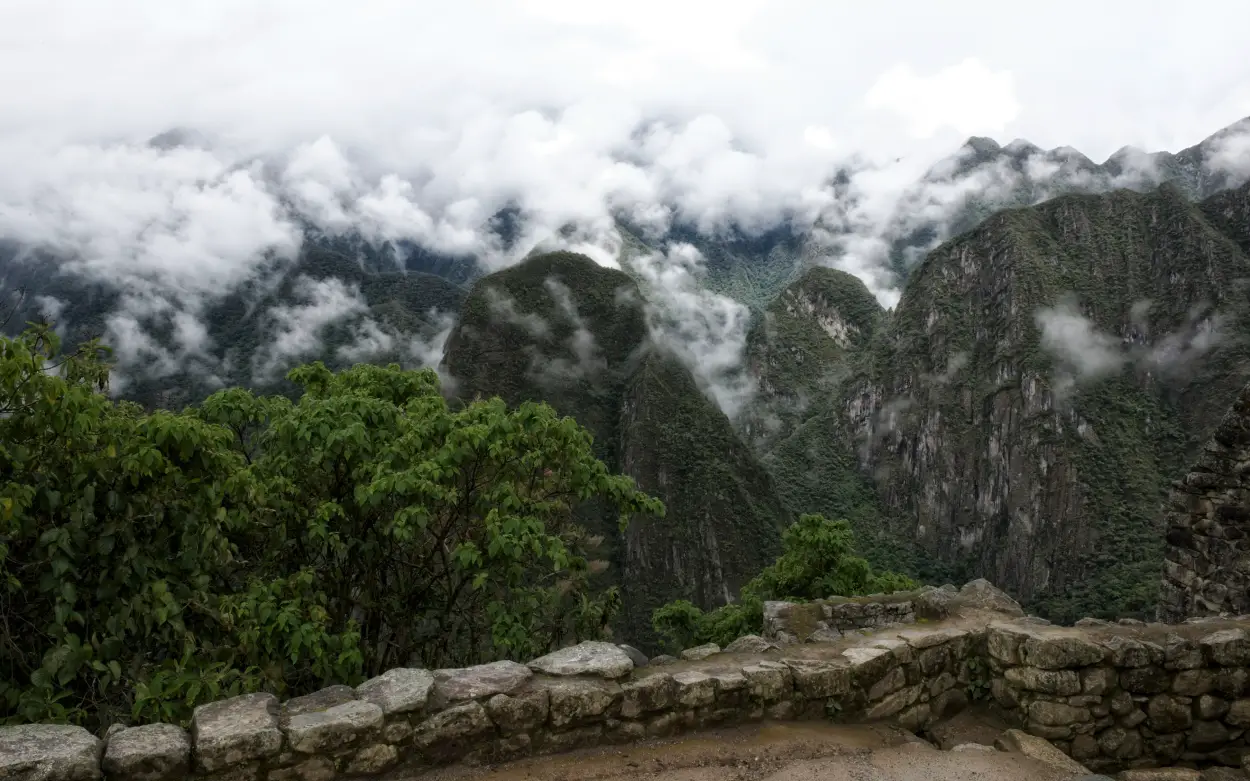 machu picchu bajo la lluvia vegetación niebla montañas humo blanco piedra roca ciudad sagrada cusco temporada de lluvia