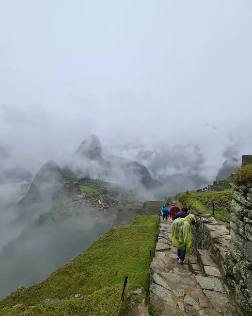 machu picchu bajo la lluvia impermeable sendero de piedra día nublado neblina ciudadela temporada de lluvia