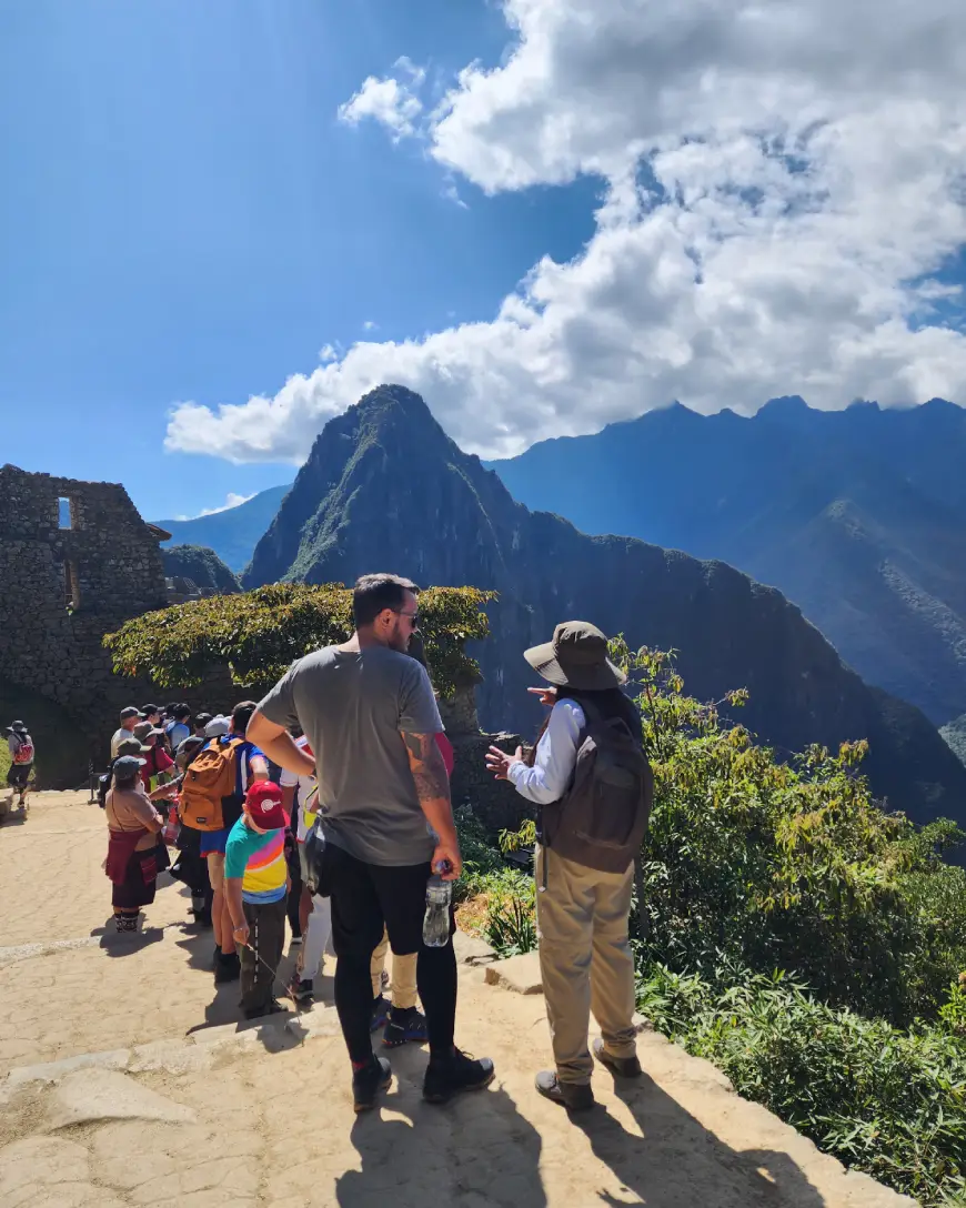 exploring Machu Picchu guide tourist clouds blue sky mountain cusco peru