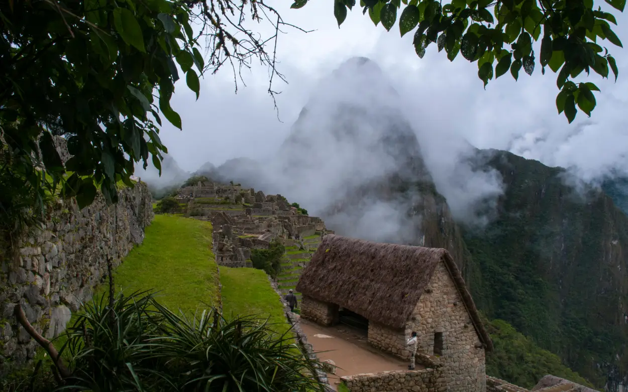 exploring Machu Picchu cusco peru mist green stone path house mountain