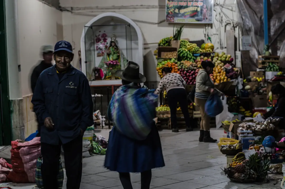 Daily life at Huancaro Market in Cusco with fruit stalls and local shoppers