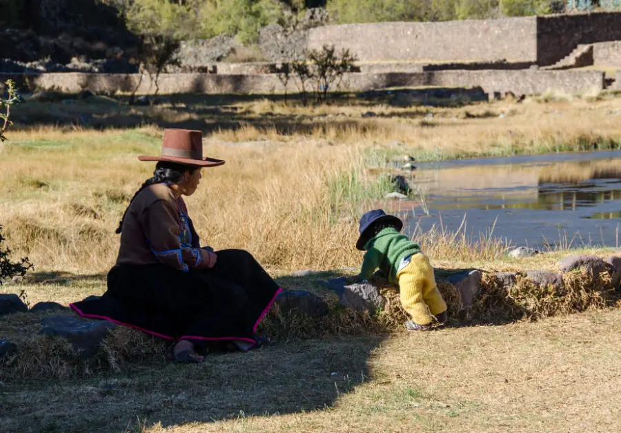 ruta del sol raqchi señora mirando a su niño vestimenta tradicional sol sombreros vegetación vida