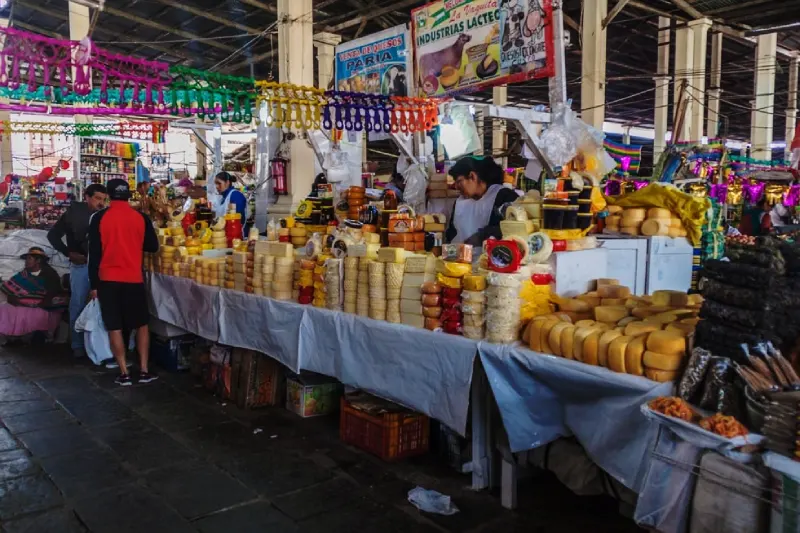 Local cheese vendor offering handmade Andean cheese at San Pedro Market.