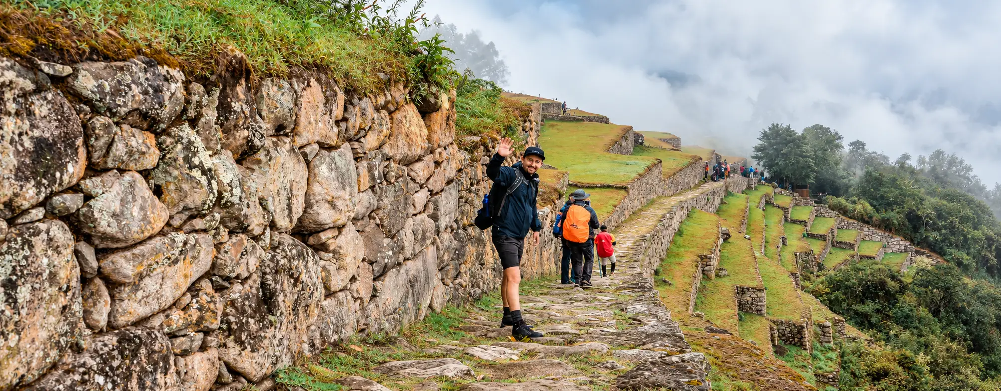 Dos excursionistas contemplando Machu Picchu desde el camino de piedra