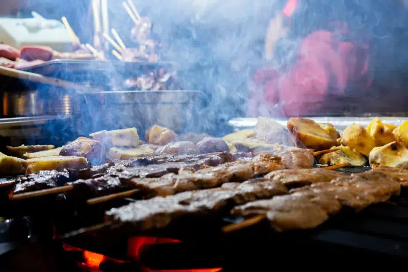 Cusco Street Food - Peruvian anticuchos grilling over charcoal with potatoes.