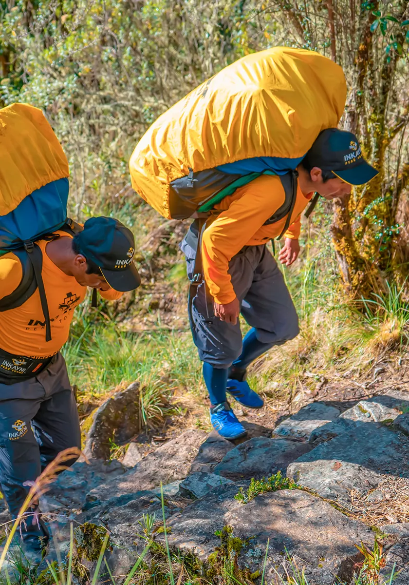 Porters carrying expedition gear uphill on the classic Inca Trail trekking route
