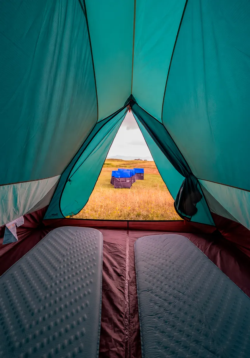 View from inside a trekking tent toward the campsite landscape on the Inca Trail